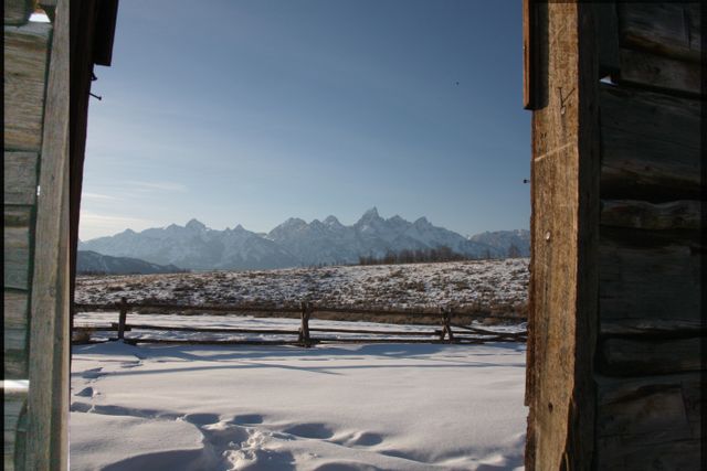 TetonsWinter -- View of Grand Tetons through window in old house 